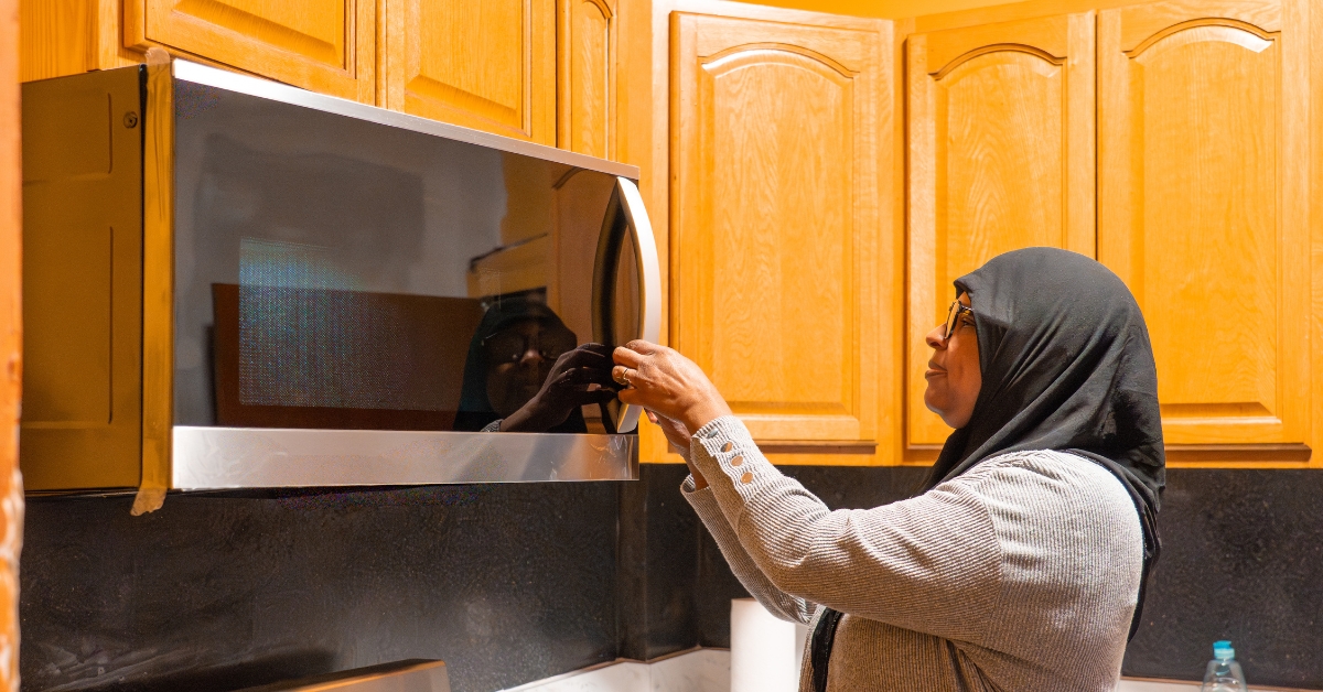 Woman opening microwave door